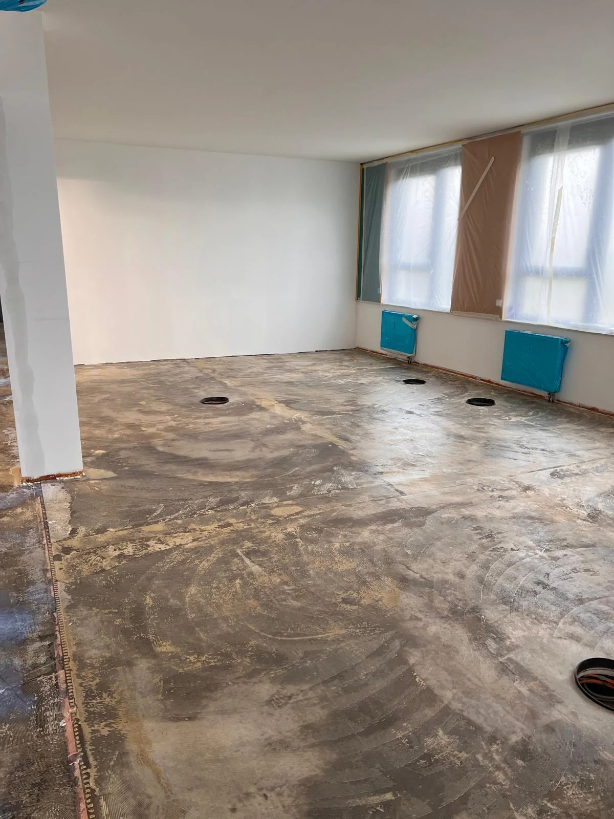 Büroraum mit freigelegtem Untergrund und Fensterband